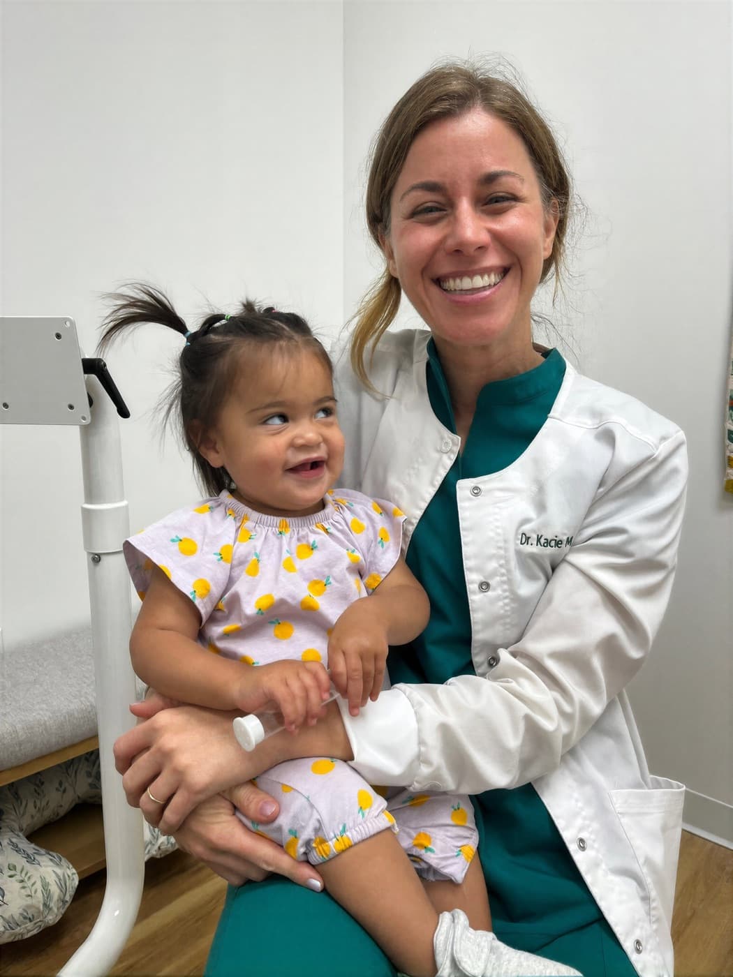 Dr. Kacie Culotta holding a smiling toddler at Latched Beginnings